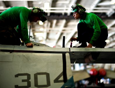US Navy 120116-N-BT887-050 A Sailor checks an electric drive for a folding wing on an F-A-18C Hornet