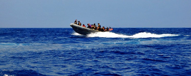 US Navy 090213-N-4774B-158 Members of a visit, board, search, and seizure team assigned to the guided-missile destroyer USS The Sullivans (DDG 68) ride a rigid-hull inflatable boat at high speed during a training exercise
