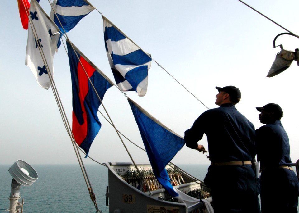 US Navy 090210-N-9134V-063 Ensign Michael Carter, left, and Chief Quartermaster Melvin Prescott hoist flags during a drill aboard the amphibious dock landing ship USS Carter Hall (LSD 50)