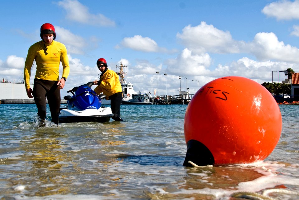 US Navy 090212-N-9689V-001 Ian Urtnowski and Lt. Pepper Lang prepare marker buoys at Smugglers Cove, Naval Base Point Loma before the start of the base's 15th annual