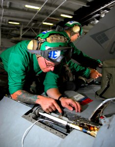 US Navy 090211-N-6597H-065 Aviation Electrician's Mate 3rd Class Jon Miller, from Waterford, Mich., performs scheduled electrical maintenance on an F-A-18C Hornet from the