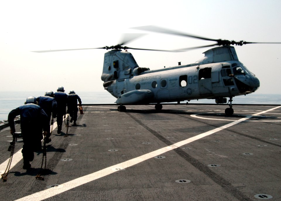 US Navy 090213-N-6692A-005 Sailors aboard the forward-deployed amphibious assault ship USS Tortuga (LSD 46) carry chocks and chains to secure a CH 46 Sea Knight helicopter during exercise Cobra Gold 09 photo