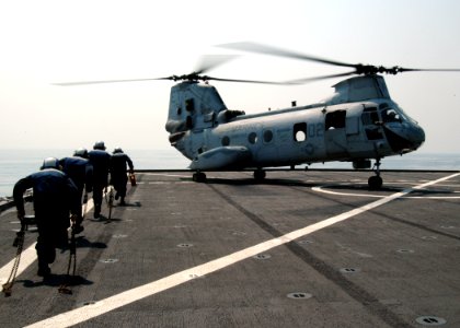 US Navy 090213-N-6692A-005 Sailors aboard the forward-deployed amphibious assault ship USS Tortuga (LSD 46) carry chocks and chains to secure a CH 46 Sea Knight helicopter during exercise Cobra Gold 09