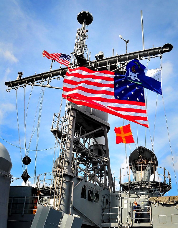 US Navy 090213-N-4774B-024 Quartermaster 1st Class Howell Trinidad hoists battle flags aboard the guided-missile cruiser USS Lake Champlain (CG 57) during exercises at sea