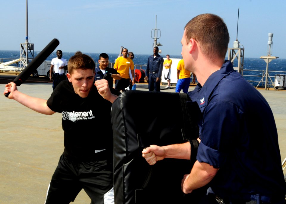 US Navy 090213-N-7280V-015 Seaman Chad Tomes demonstrates a self-defensive baton striking technique aboard the main deck of amphibious command ship USS Blue Ridge (LCC 19)