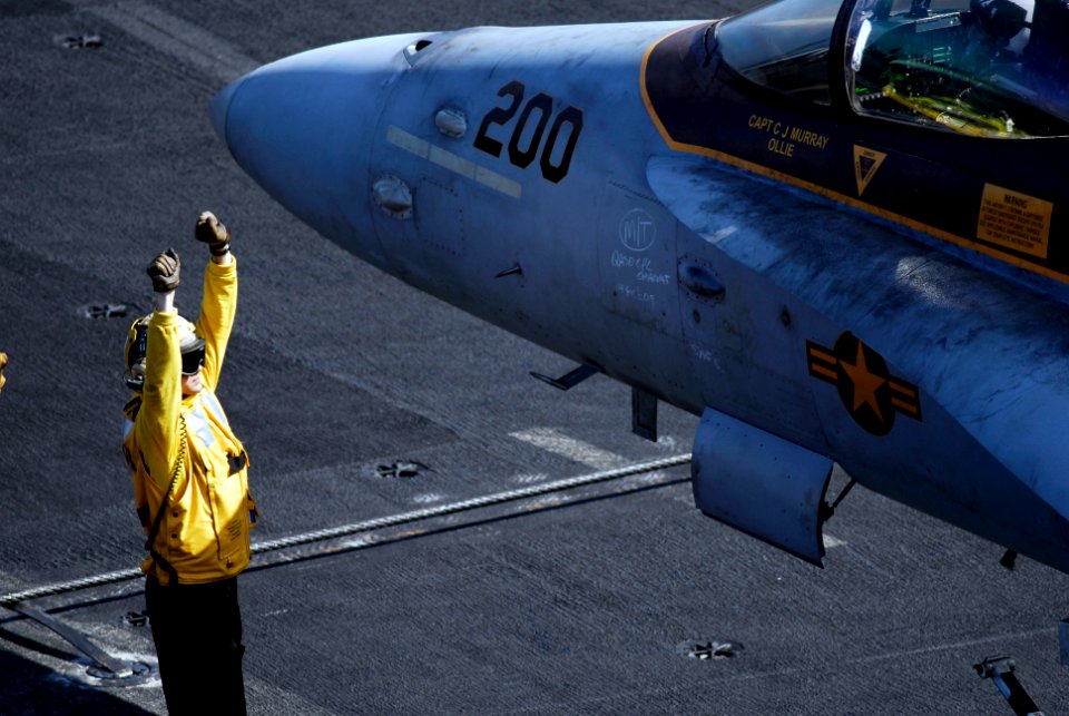 US Navy 090215-N-8517C-803 Aviation Boatswain's Mate (Handling) 1st Class Beau Pepin gives hand signals to the pilot of an F-A-18C