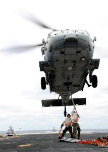 US Navy 090218-N-2636M-146 Marines assigned to the 22d Marine Expeditionary Unit (MEU) latch a net sling to an MH-60S Sea Hawk helicopter during a vertical replenishment aboard the amphibious assault ship USS Bataan (LHD 5)