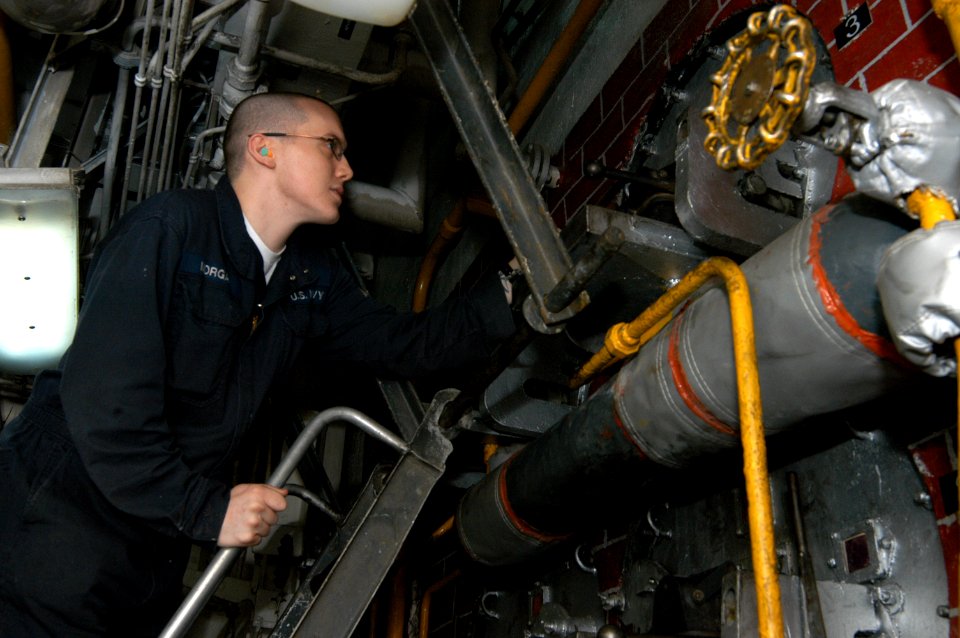US Navy 090214-N-2636M-052 Fireman Christopher R. Morgan checks on the fire in the number one boiler in the main machinery room aboard USS Bataan (LHD 5)