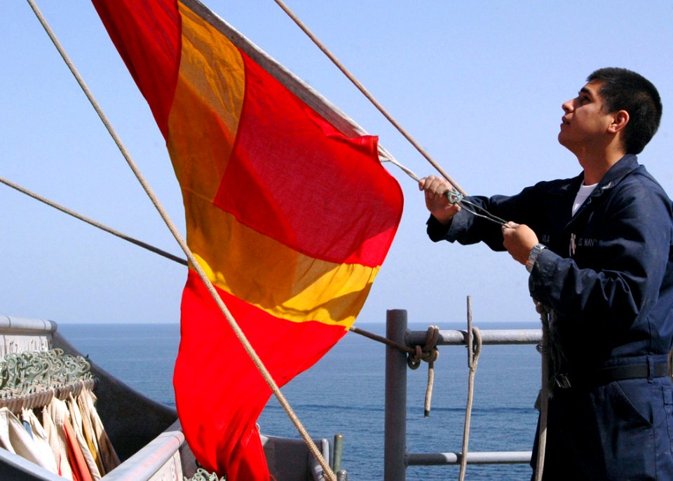 US Navy 090217-N-9134V-006 Quartermaster 3rd Class Perry Avila hoists a Romeo flag during a replenishment at sea