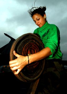 US Navy 090216-N-6538W-205 Aviation Boatswain's Mate (Equipment) Airman Apprentice Angela Fuga, from St. Clair, Mich., rolls a hose after cleaning catapult deck plates aboard the Nimitz-class aircraft carrier USS John C. Stenni
