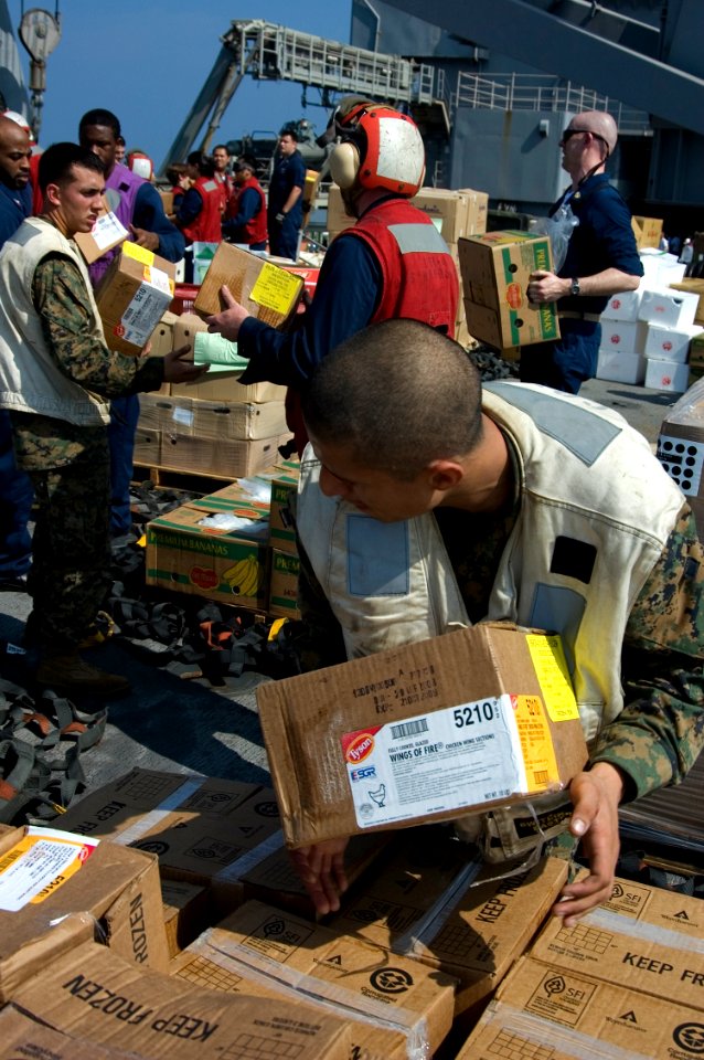 US Navy 090216-N-1251W-147 Sailors and Marines aboard the amphibious dock landing ship USS Harpers Ferry (LSD 49) form a working party to move stores from the ship's flight deck during a vertical replenishment