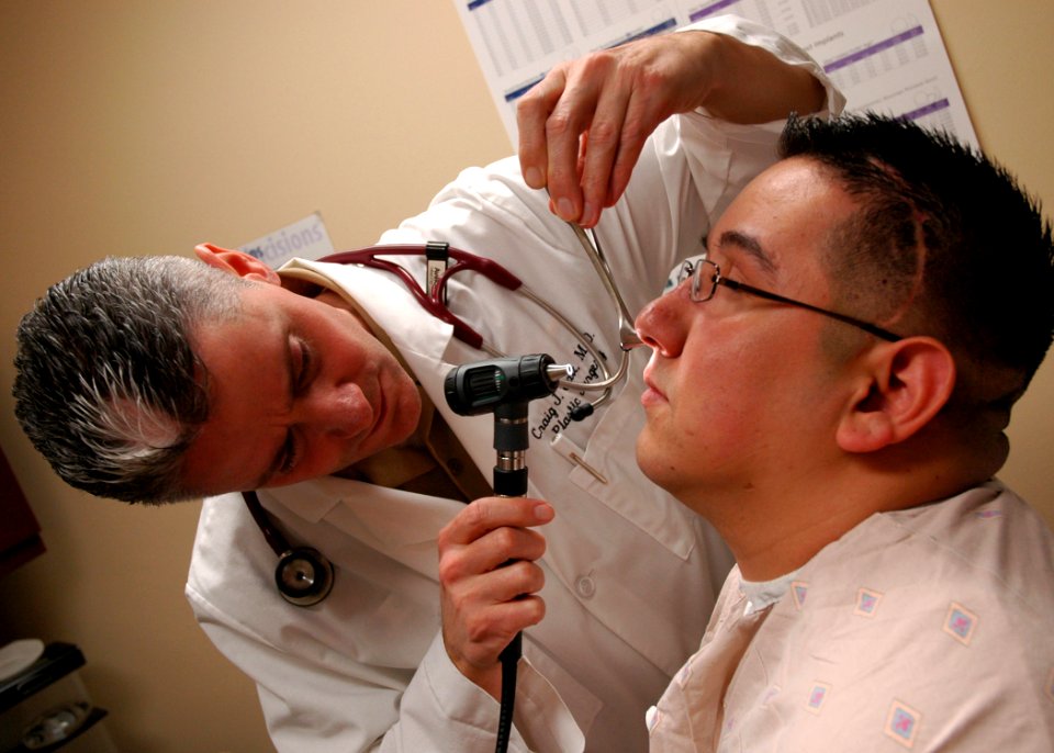 US Navy 090217-N-6326B-002 Cmdr. Craig Salt, department head of plastic surgery at Naval Medical Center San Diego, examines the nasal cavity of Lance Cpl. Anthony Guererro