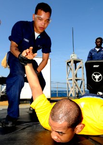 US Navy 090213-N-7280V-070 Storekeeper Seaman Sergio Torres teaches Ship's Serviceman Seaman Stephen C. Graham how to execute a proper holding technique for an arrest