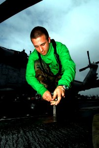 US Navy 090216-N-6538W-210 Aviation Boatswain's Mate (Equipment) Airman Halston Mather, from St. Louis, tightens bolts on catapult deck plates aboard the Nimitz-class aircraft carrier USS John C. Stennis (CVN 74)