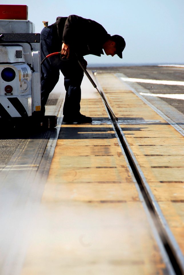 US Navy 090219-N-9760Z-017 Aviation Boatswain's Mate (Equipment) Airman Aaron Patterson pressure washes catapult number four aboard USS Nimitz (CVN 68)