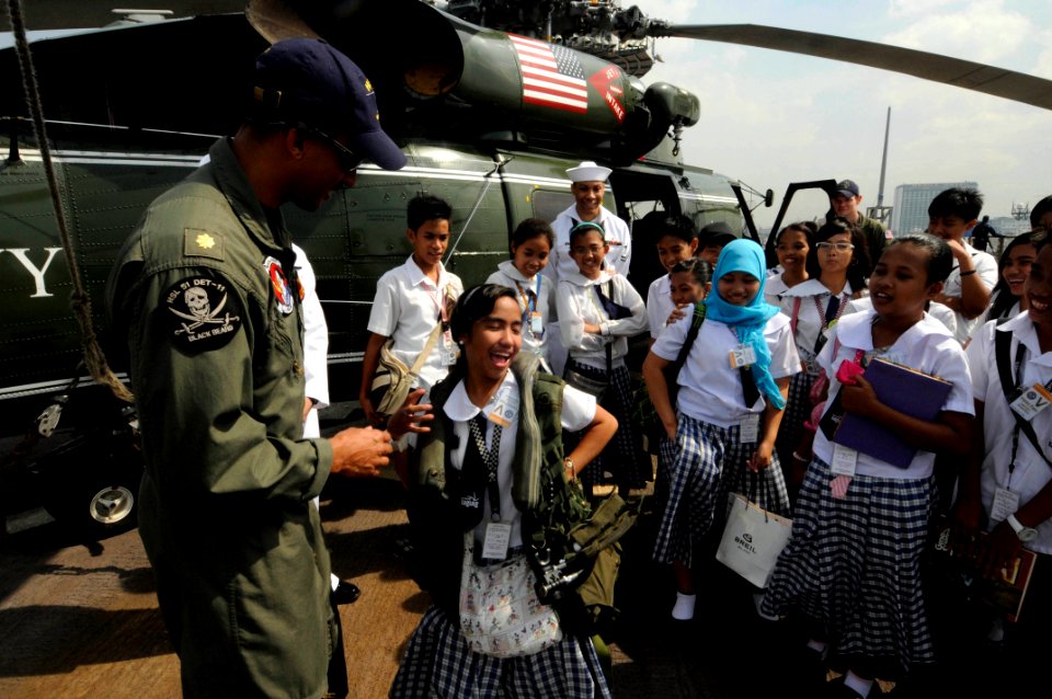 US Navy 090220-N-3830J-236 Lt. Cmdr. Loren Romeus, air boss for Anti-Submarine Squadron Light (HSL) 51 Detachment 11, allows students from the Taguig National High School to wear an air save vest