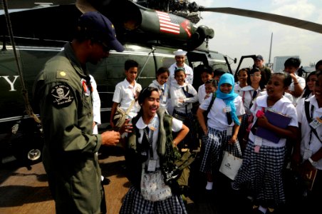 US Navy 090220-N-3830J-236 Lt. Cmdr. Loren Romeus, air boss for Anti-Submarine Squadron Light (HSL) 51 Detachment 11, allows students from the Taguig National High School to wear an air save vest