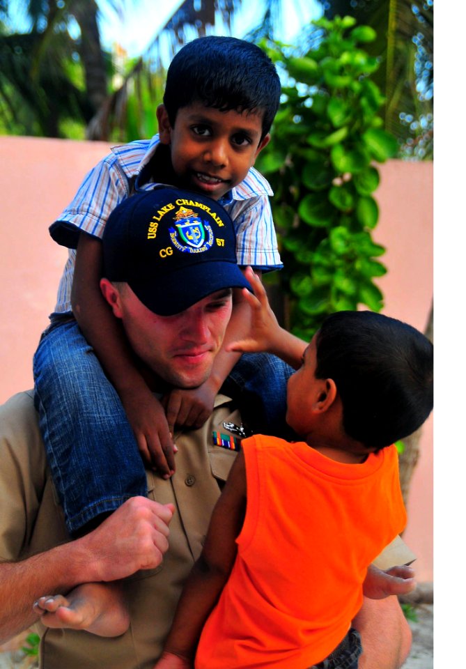 US Navy 090220-N-4774B-040 Gunner's Mate 2nd Class Alvin Johnson entertains children during a Project Handclasp community relations event
