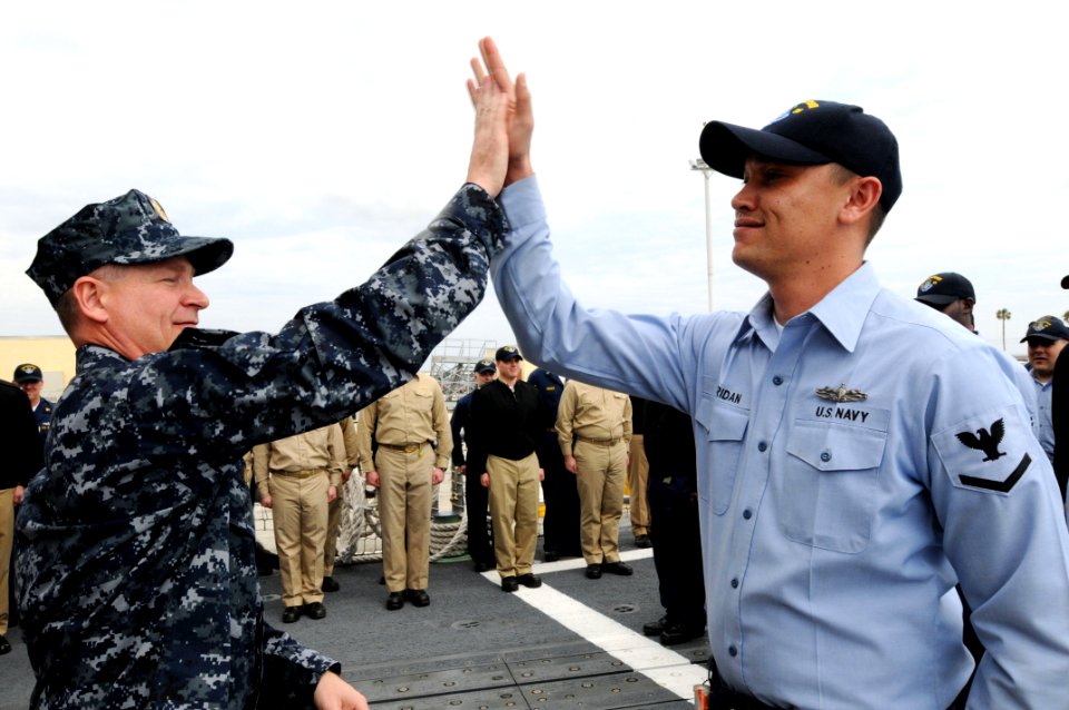 US Navy 090218-N-9818V-297 Master Chief Petty Officer of the Navy (MCPON) Rick West congratulates Machinery Repairman 3rd Class Joshua Sheridan for earning his Enlisted Surface Warfare Specialist pin