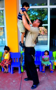 US Navy 090220-N-4774B-015 Gunner's Mate 3rd Class Joahn Tinjaca entertains a child during a Project Handclasp community relations event