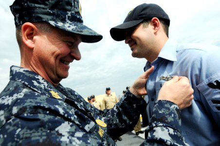 US Navy 090218-N-9818V-276 Master Chief Petty Officer of the Navy (MCPON) Rick West pins the Enlisted Surface Warfare Specialist Insignia on Interior Communications Electrician 2nd Class Jason Stawski during a ceremony aboard t