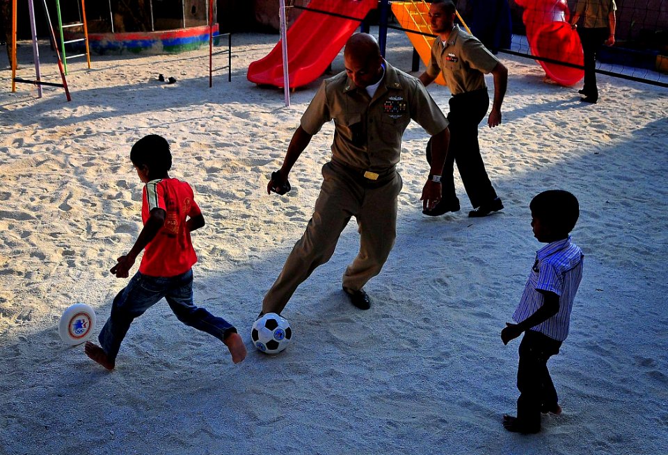 US Navy 090220-N-4774B-055 Chief Intelligence Specialist Dwayne Edmond and Sailors play games with children at the Kuda Kudhin ge Hiya neglected children's home in Villingili