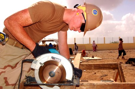 US Navy 090219-N-1057H-074 Builder Constructionman Recruit Heston Scott cuts lumber for a project at the Douda Ecole School Cantina