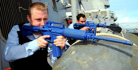US Navy 090219-N-9758L-176 onar Technician (Surface) 2nd Class Aaron Wellborn and Sonar Technician (Surface) 2nd Class Kyle Wilcox take a protective posture stance during a small boat attack drill
