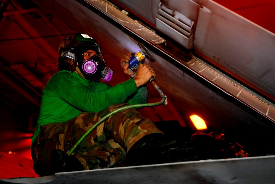 US Navy 090222-N-2475A-068 Aviation Structural Mechanic 3rd Class Bradley Wroblos sands corrosion from the wing of an EA-6B Prowler