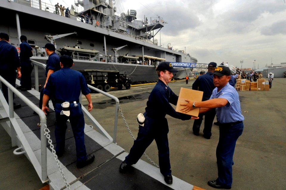 US Navy 090219-N-7280V-073 A Sailor assigned to the amphibious command ship USS Blue Ridge (LCC 19) passes a box of books to a member of the Armed Forces of the Philippines Navy