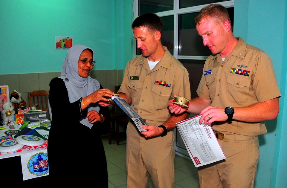 US Navy 090220-N-4774B-064 The head of staff of the Kuda Kudhin ge Hiya neglected children's home in Villingili presents Chaplain Lt. j.g. Jarrod Johnson and Lt. j.g. Malcolm Lybeck with gifts