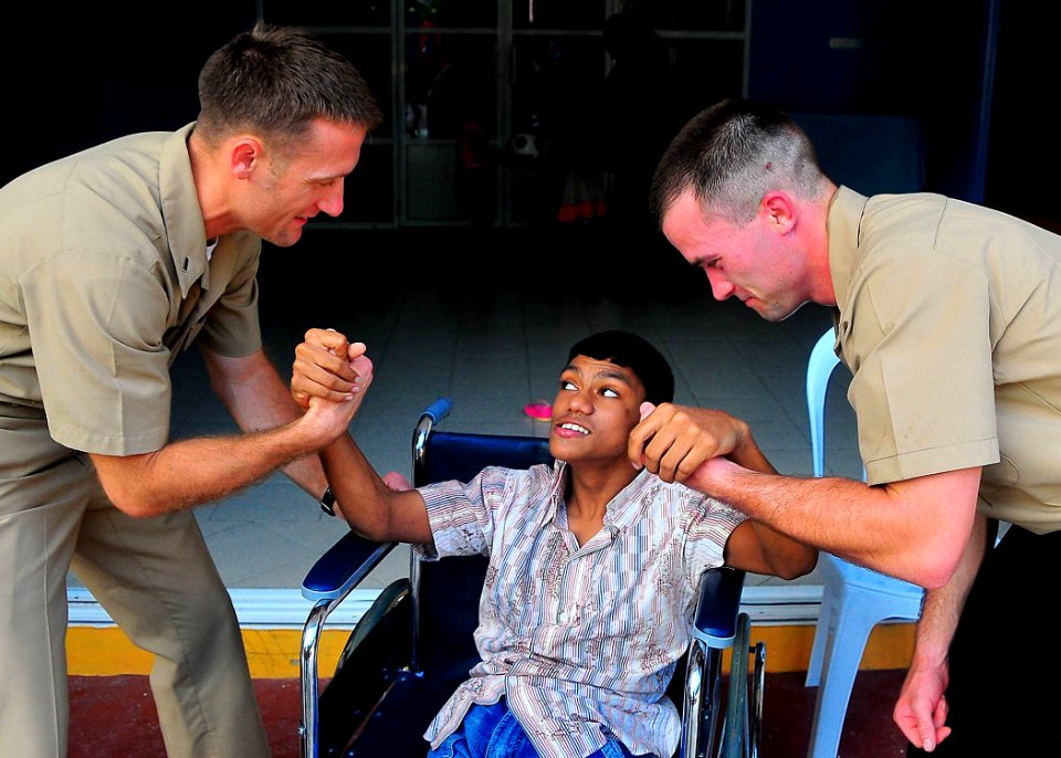 US Navy 090220-N-4774B-029 Lt. j.g. Jarrod Johnson, left, a chaplain assigned to the guided-missile cruiser USS Lake Champlain (CG 57), and Gunner's Mate 2nd Class Alvin Johnson interact with a child