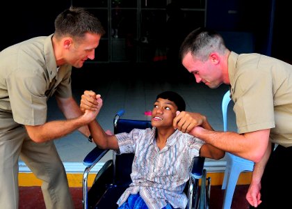 US Navy 090220-N-4774B-029 Lt. j.g. Jarrod Johnson, left, a chaplain assigned to the guided-missile cruiser USS Lake Champlain (CG 57), and Gunner's Mate 2nd Class Alvin Johnson interact with a child