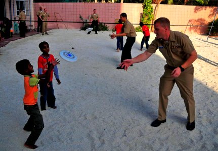 US Navy 090220-N-4774B-056 Lt. j.g. Malcolm Lybeck and Sailors throw frisbees with children at the Kuda Kudhin ge Hiya neglected children's home in Villingili photo