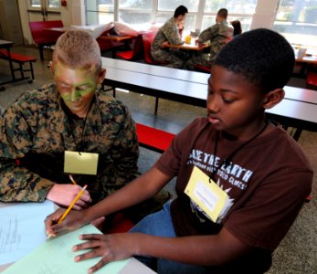 US Navy 090221-N-5328N-140 Saturday Scholar Mentor Pfc. Mathew Alexander, from Hendersonville, N.C., plays tick-tack-toe with a West Pensacola Elementary School Saturday Scholar student photo
