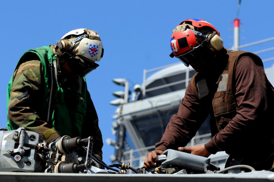 US Navy 090220-N-3610L-283 Aviation Structural Mechanic 1st Class Ernesto Pagulayanl Aviation Structural Mechanic Airman Alan Alexander sit atop a SH-60 Sea Hawk