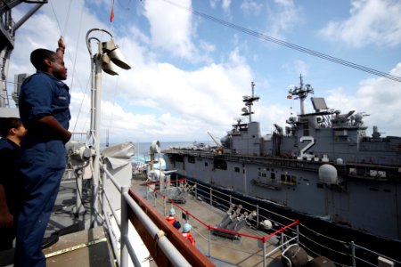 US Navy 090224-N-1251W-020 Quartermaster 2nd Class Matthew Brooks, assigned to the amphibious dock landing ship USS Harpers Ferry (LSD 49), performs semaphore signaling to the amphibious assault ship USS Essex (LHD 2)
