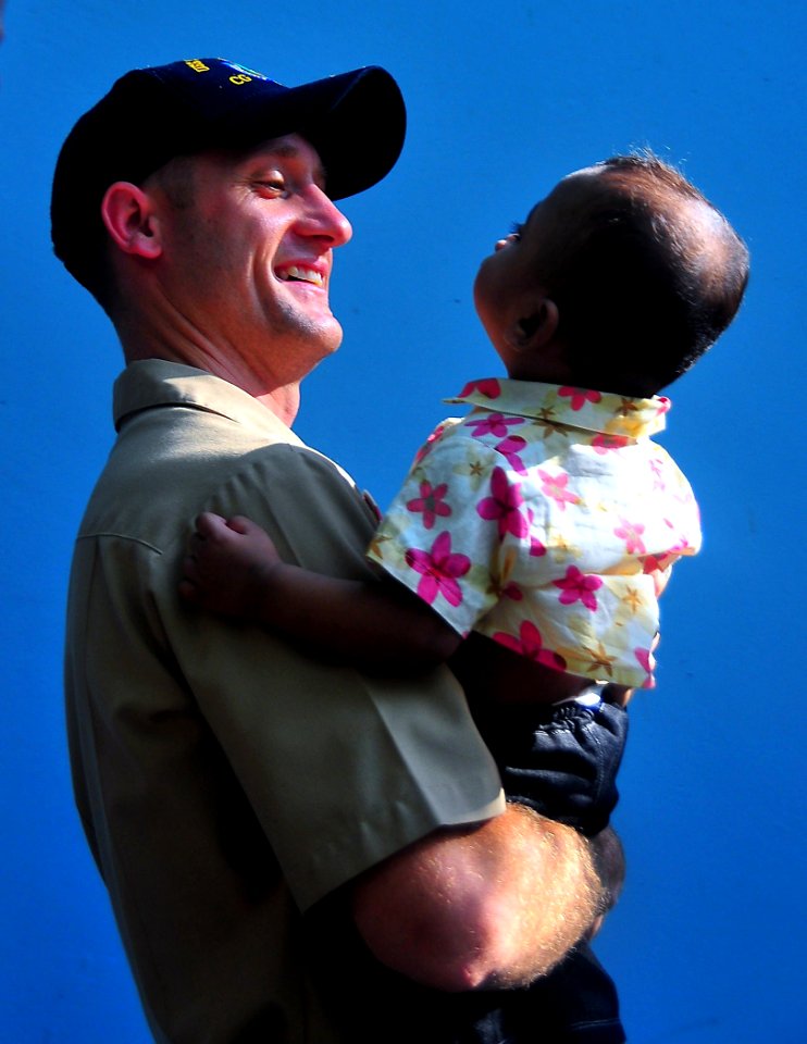 US Navy 090220-N-4774B-001 Lt. j.g. Jarrod Johnson holds a small child during a Project Handclasp community relations event