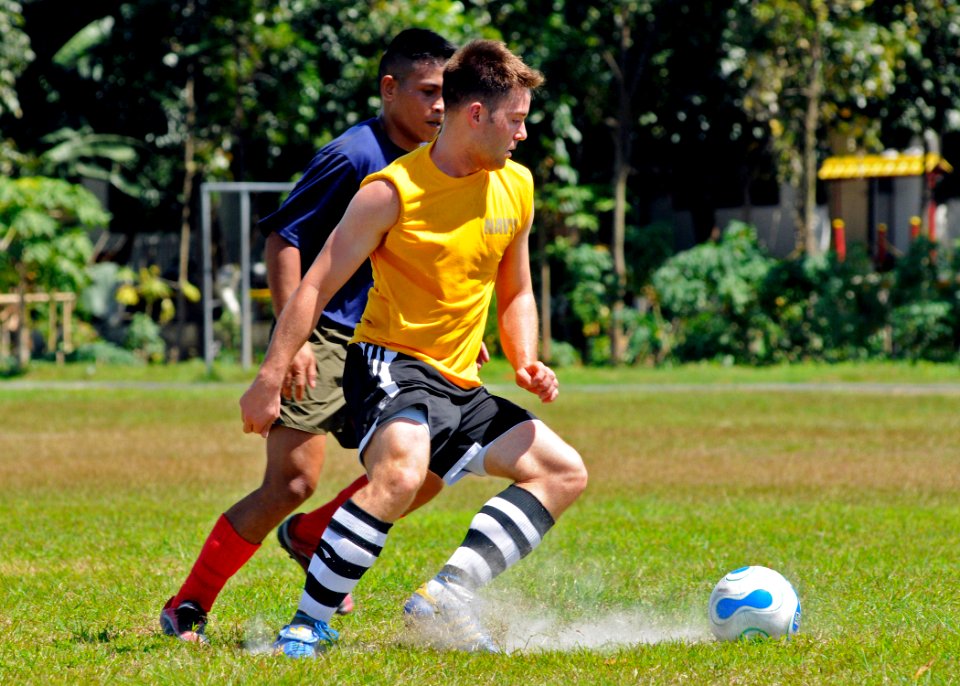 US Navy 090221-N-3830J-146 Information Systems Technician 2nd Class Kevin M. Abney, assigned to the amphibious command ship USS Blue Ridge (LCC 19), advances past a defender during a soccer match