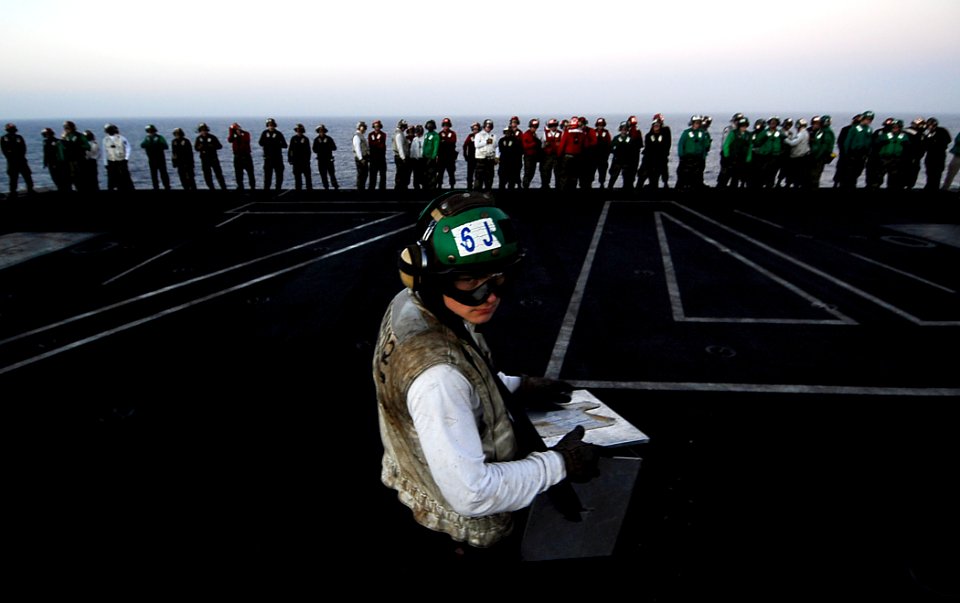 US Navy 090222-N-6538W-157 Aviation Machinist's Mate Airman Alex Davies, from Vladivostok, Russia, holds a container for debris found on the flight deck during a foreign object debris walk down