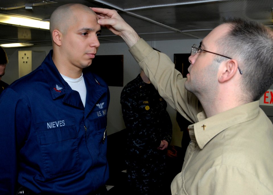 US Navy 090225-N-4014G-008 Air Traffic Controller 2nd class Alejandro Nieves receives the Imposition of Ashes from Navy Chaplain Lt. Chris Stanfield during an Ash Wednesday Mass in the chapel aboard the aircraft carrier USS Dwi