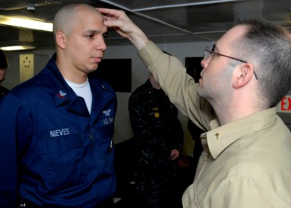 US Navy 090225-N-4014G-008 Air Traffic Controller 2nd class Alejandro Nieves receives the Imposition of Ashes from Navy Chaplain Lt. Chris Stanfield during an Ash Wednesday Mass in the chapel aboard the aircraft carrier USS Dwi