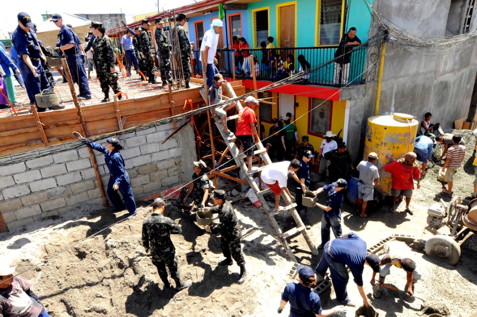 US Navy 090221-N-8546L-745 Sailors embarked aboard the amphibious command ship USS Blue Ridge (LCC 19) and members of the Armed Forces of the Philippines Navy work with local citizens to build a multi-tenant housing unit