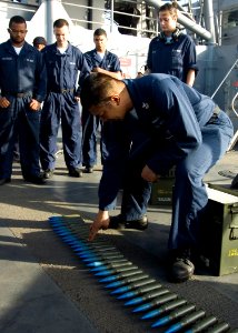 US Navy 090226-N-1251W-002 Gunners Mate 1st Class Leland Pasion explains how to inspect rounds for safety before a live-fire exercise aboard the amphibious dock landing ship USS Harpers Ferry (LSD 49)