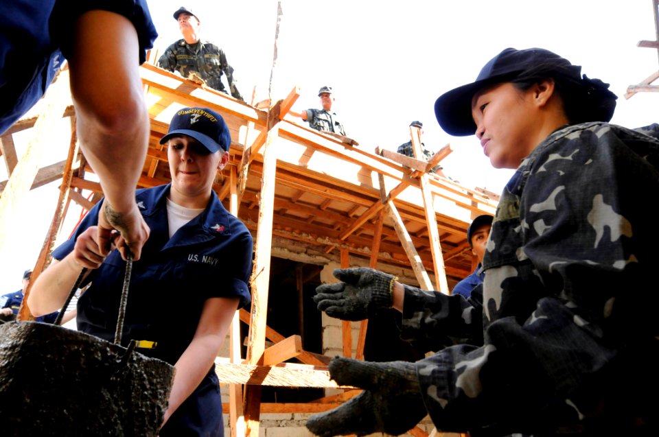 US Navy 090221-N-8546L-392 ntelligence Specialist 2nd Class Jessica Helms, assigned to the U.S. 7th Fleet staff embarked aboard the amphibious command ship USS Blue Ridge (LCC 19), passes a bucket of concrete to a sailor from t