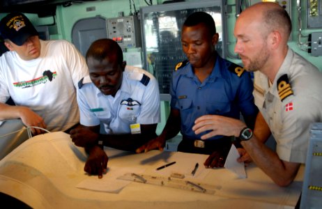 US Navy 090227-N-1688B-025 Royal Danish Navy Lt. Cmdr. Daniel Christensen, right, gives navigation training to Ghanaian Naval and Air Force officers aboard the amphibious transport dock ship USS Nashville (LPD 13)