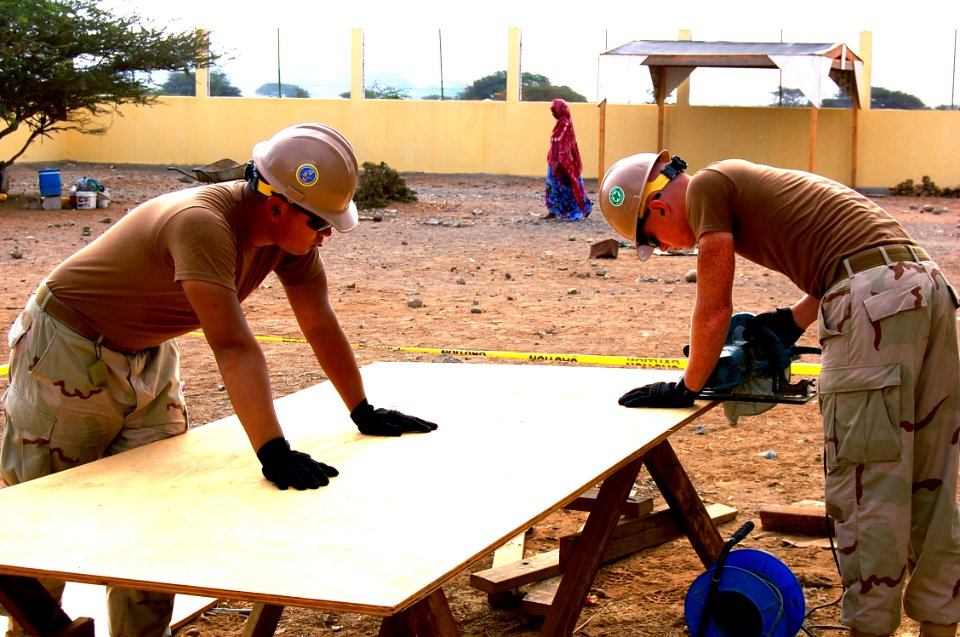 US Navy 090226-N-1057H-097 Seabees from Naval Mobile Construction Battalion (NMCB) 11 cut plywood for a water storage tank at Ecole de Douda primary school