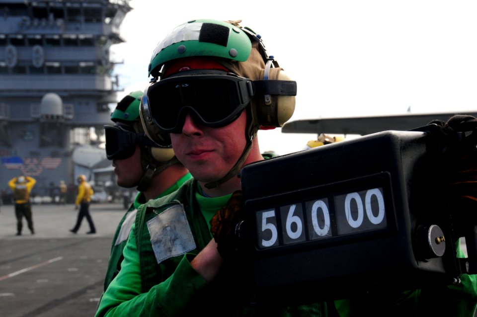 US Navy 090225-N-3946H-050 Aviation Boatswain's Mate (Equipment) 3rd Class Doug Bellew displays the weight of an F-A-18F Super Hornet