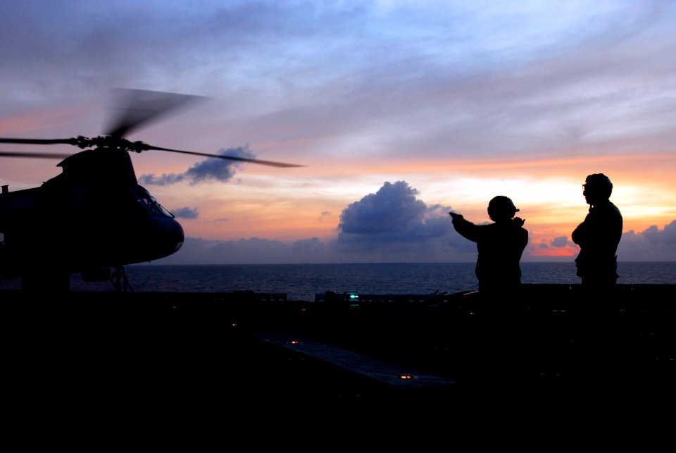 US Navy 090225-N-9950J-145 Aviation Boatswain's Mate (Handling) Airman David Neiman, left, and Aviation Boatswain's Mate (Handling) 3rd Class Apolinar Garcia prepare to move a CH-46E Sea Knight helicopter during evening flight