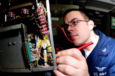 US Navy 090227-N-9760Z-015 Aviation Electronics Technician 3rd Class Ivan Indreland checks for continuity in a radar control panel
